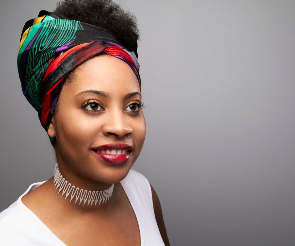 Stylish portrait featuring a young woman wearing a colorful turban and vibrant red lipstick, showcasing natural beauty.