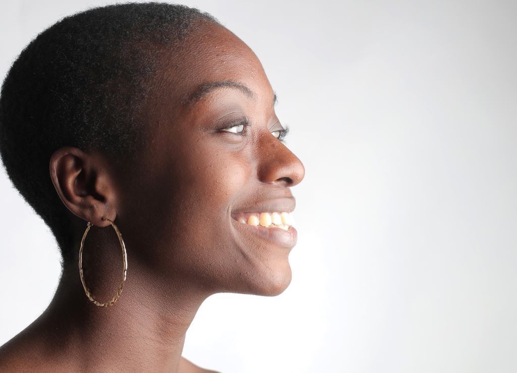 Beautiful side profile portrait of a smiling woman exuding confidence.